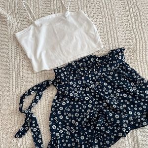 She in High waisted navy blue shorts with white tank